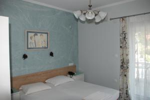 a bedroom with a bed and a picture on the wall at Diaporos Hotel in Vourvourou
