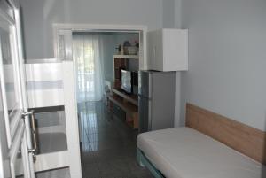 a small room with a bed and a microwave at Diaporos Hotel in Vourvourou