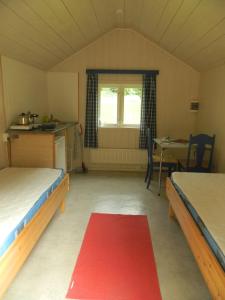Habitación con 2 camas y alfombra roja. en Eidfjord Hytter en Eidfjord
