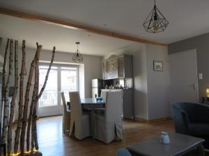 a living room with a table and a kitchen at La chenevière in Saint-Rémy-de-Chargnat +32 photos