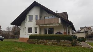 a white house with a balcony on top of it at Ferienappartement Kassel-Waldau in Kassel