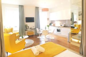 een woonkamer met gele stoelen en een keuken bij Croix Rousse Prestige - Lyon Centre - Majord'Home in Lyon