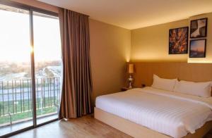 um quarto de hotel com uma cama e uma grande janela em The 28th Hotel em Kanchanaburi