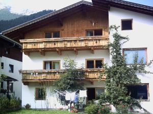 a large white building with a wooden balcony at Appartement Ambrosius in Lermoos