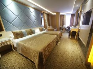 a hotel room with two beds and a desk at The Parma Hotel Downtown in Istanbul
