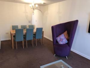 a dining room with a table and a purple chair at The Apartment in Northallerton