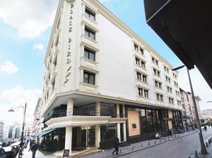 un grand bâtiment blanc dans une rue de la ville dans l'établissement The Parma Hotel Downtown, à Istanbul