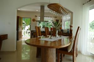 a dining room with a wooden table and chairs at Villa Karibu in Au Cap