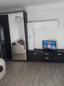 a living room with a tv and a mirror at Complex Astoria mamaia nord in Mamaia Nord