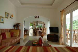 a living room with a couch and a table at Villa Karibu in Au Cap