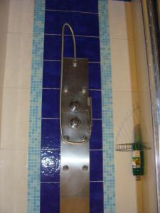 a shower in a bathroom with blue tiles at Świnoujscie-Platan in Świnoujście