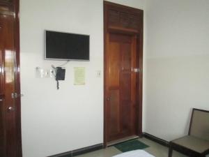 Habitación con puerta y TV en la pared en Khách Sạn Sơn Hạ, en Kon Tum 19 fotos más