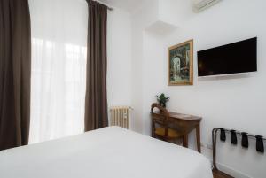 ローマにあるSotto La Cupolaのベッドルーム(ベッド1台、テレビ、デスク付)