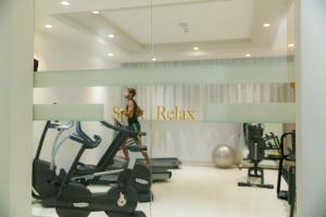 a woman walking on a treadmill in a gym at Hotel Terme Venezia in Abano Terme