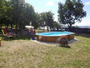 a swimming pool in a yard with chairs and flowers at Chalet 2 pers. + Bébé in Montolieu