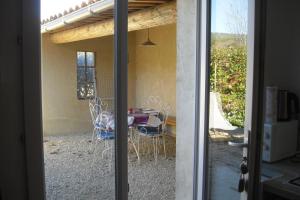 a view of a patio with a table and chairs at Le Prunier Lou Mas Li Pitchoun in Gordes