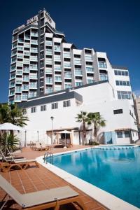 un hotel con piscina e un grande edificio di La Familia Gallo Rojo a El Campello