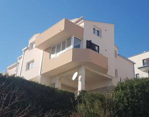 une maison blanche au sommet d'une colline dans l'établissement Apartments Kike&Ana, à Split