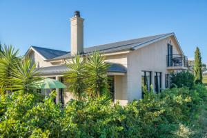 a white house with a chimney and palm trees at Barossa Shiraz Estate in Lyndoch