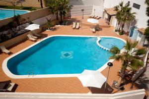 uma vista superior de uma piscina com guarda-sóis em La Familia Gallo Rojo em El Campello