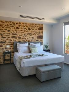 ein Schlafzimmer mit einem großen Bett mit Ziegelwand in der Unterkunft Barossa Shiraz Estate in Lyndoch