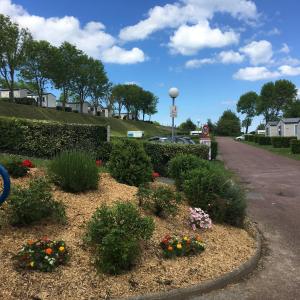 a garden with flowers on the side of a road at Camping le Mont Joli Bois in Criel-sur-Mer