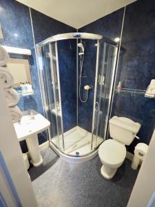 a bathroom with a shower and a toilet and a sink at Cowrie Guest House in Berwick-Upon-Tweed