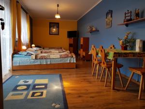 una camera con letto, tavolo e sedie di Wynajem Pokoi Willa Pod Lasem a Karpacz