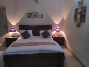 a bedroom with a large bed with two lamps at Pyramid International Guest House in Islamabad