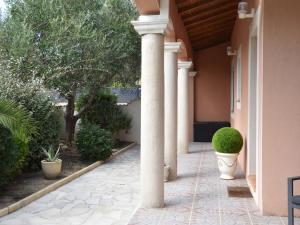 een veranda van een huis met een zuil en planten bij Luxury holiday home with private pool in Le Grau-du-Roi