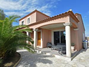 a house with a patio and a palm tree at Luxury holiday home with private pool in Le Grau-du-Roi