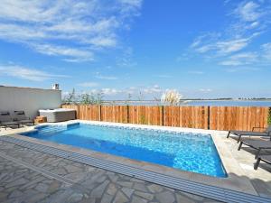 een zwembad in een achtertuin met een houten hek bij Luxury holiday home with private pool in Le Grau-du-Roi