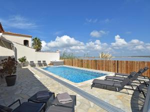 a swimming pool with lounge chairs and a fence at Luxury holiday home with private pool in Le Grau-du-Roi