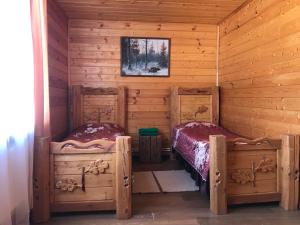 a room with two beds in a log cabin at Baza otdyha Polushkino in Spas-Klepiki