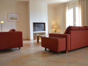 a living room with two red chairs and a tv at Modern Villa with Private Pool in Cabris in Cabris