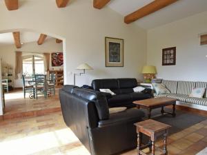 a living room with a black leather couch and a table at Provencal air conditioned villa in Fayence