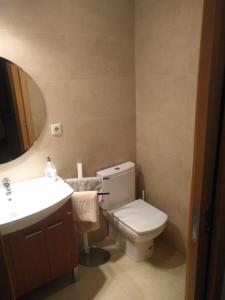 a bathroom with a toilet and a sink and a mirror at Beach Apartment in Vilanova i la Geltrú