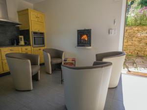 a room with chairs and a kitchen with a stove at Graceful Holiday Home in Montclar with bubble bath in Montclar