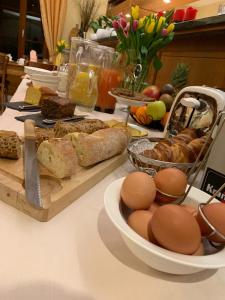 una mesa con pan, huevos y otros alimentos. en Auberge Communale à l'Union, en Gilly