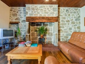 a living room with a couch and a stone fireplace at Comfortable holiday home with garden in Cassaniouze