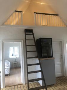 Habitación con litera y escalera con microondas. en Boes Bed & Breakfast en Skanderborg