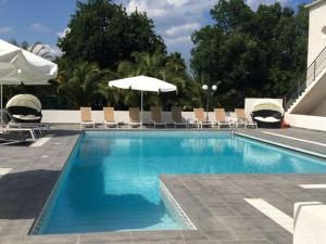 a large swimming pool with chairs and umbrellas at Beautiful holiday home near Moriani Plage in San-Nicolao