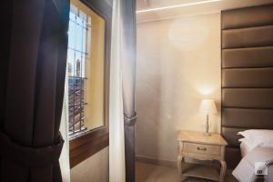 a bedroom with a bed and a window and a table at Hotel Cavour in Bologna