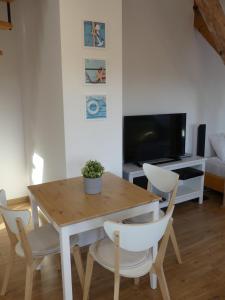 a dining room with a table and chairs and a tv at Apartament Pola & Tola in Sopot