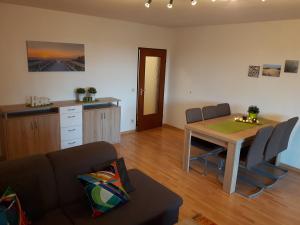 a living room with a table and a kitchen at Ferienwohnung Schiffsblick Horumersiel in Wangerland