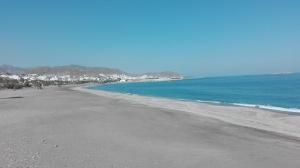 vistas a una playa con el océano y a los edificios en Apartamento turístico en C/ Los Barquicos, en Carboneras