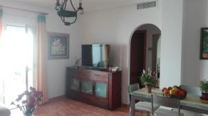 sala de estar con TV en la parte superior de un tocador en Apartamento turístico en C/ Los Barquicos, en Carboneras