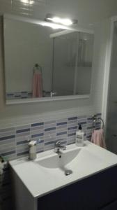 y baño con lavabo blanco y espejo. en Apartamento turístico en C/ Los Barquicos, en Carboneras