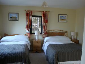 
a bedroom with two beds and two windows at Clifford House B & B in Rosslare
