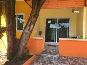 卡圖的住宿－卡圖沃富度假屋，一座橘色房子,前面有一棵树